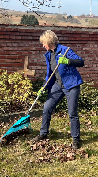 Pfarrerin beim Laubrechen